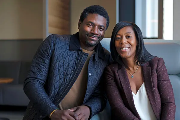 Rectal cancer survivor Roxanne Joseph, sitting with her husband and smiling, had surgery at MSK. 