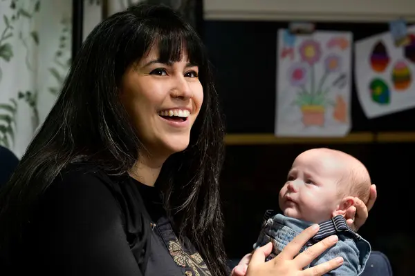 Rectal cancer survivor Dana Vergara is smiling and holding the baby she was able to have after a new surgery done at MSK. 