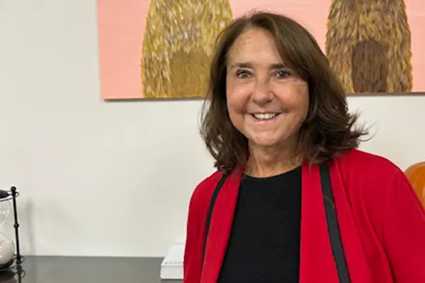 Family photo of Karren Tyler standing in front of a large pumpkin and artwork.