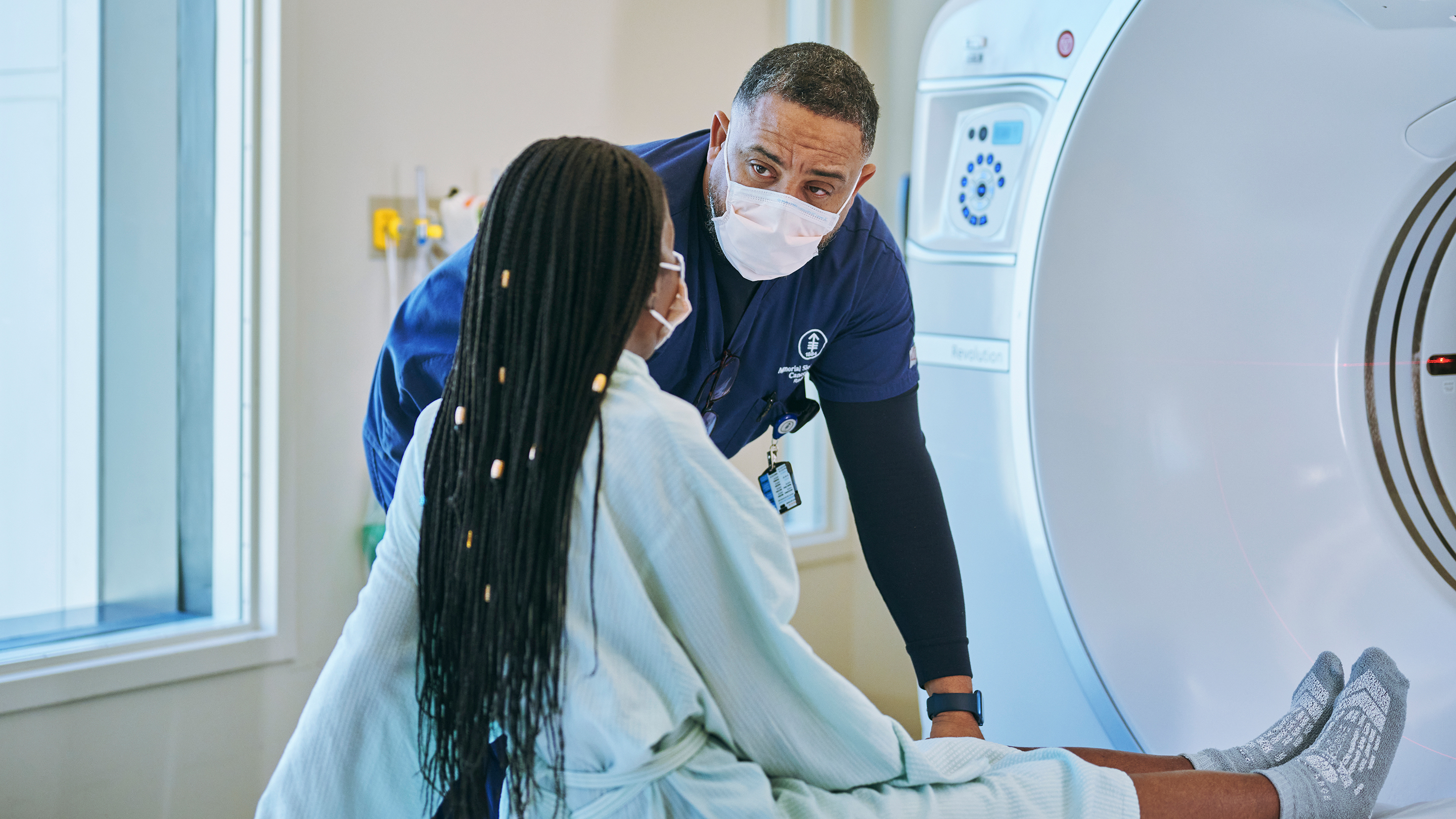 CT technologist Harry Clarke gets a patient ready for a CT scan.
