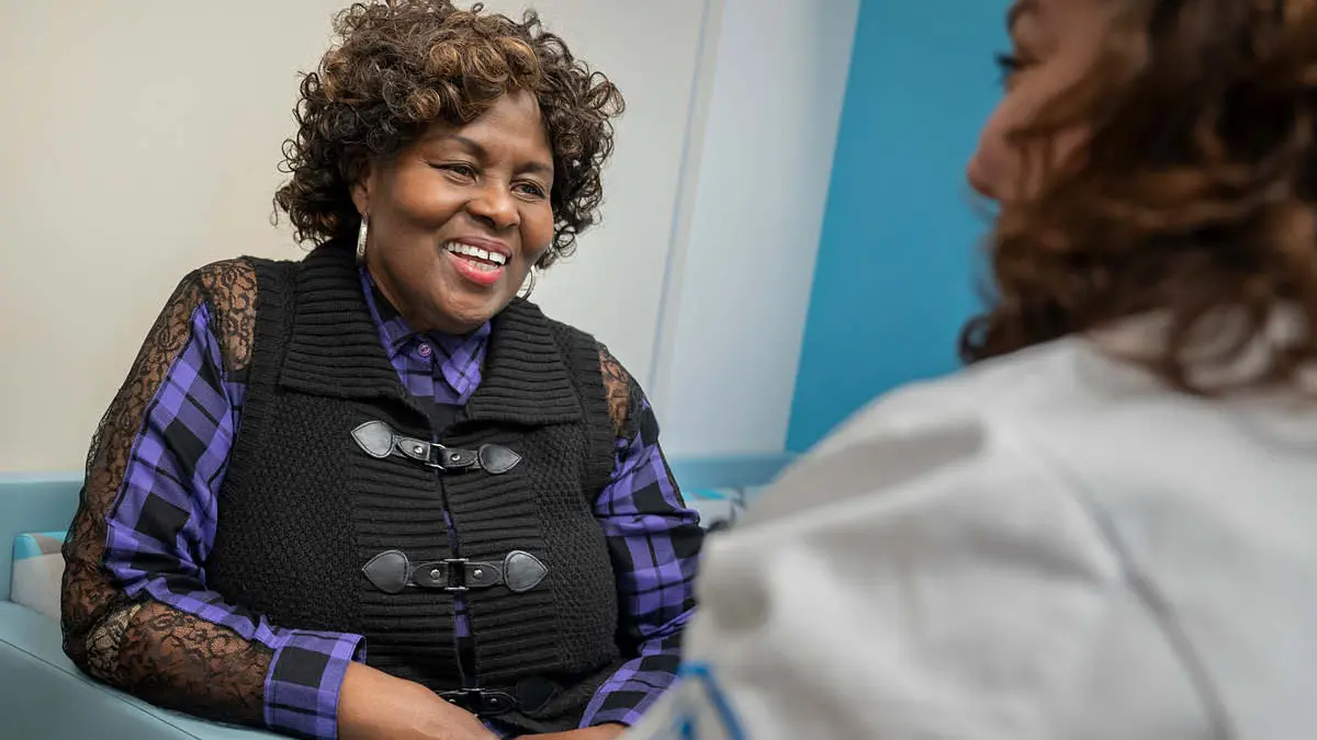 Ingrid Adams speaks with nurse practitioner Virginia Ferreira.