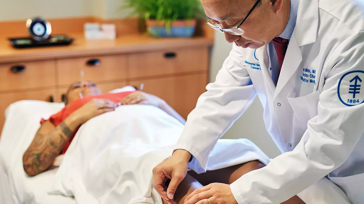 Jun Mao administers acupuncture to a patient.