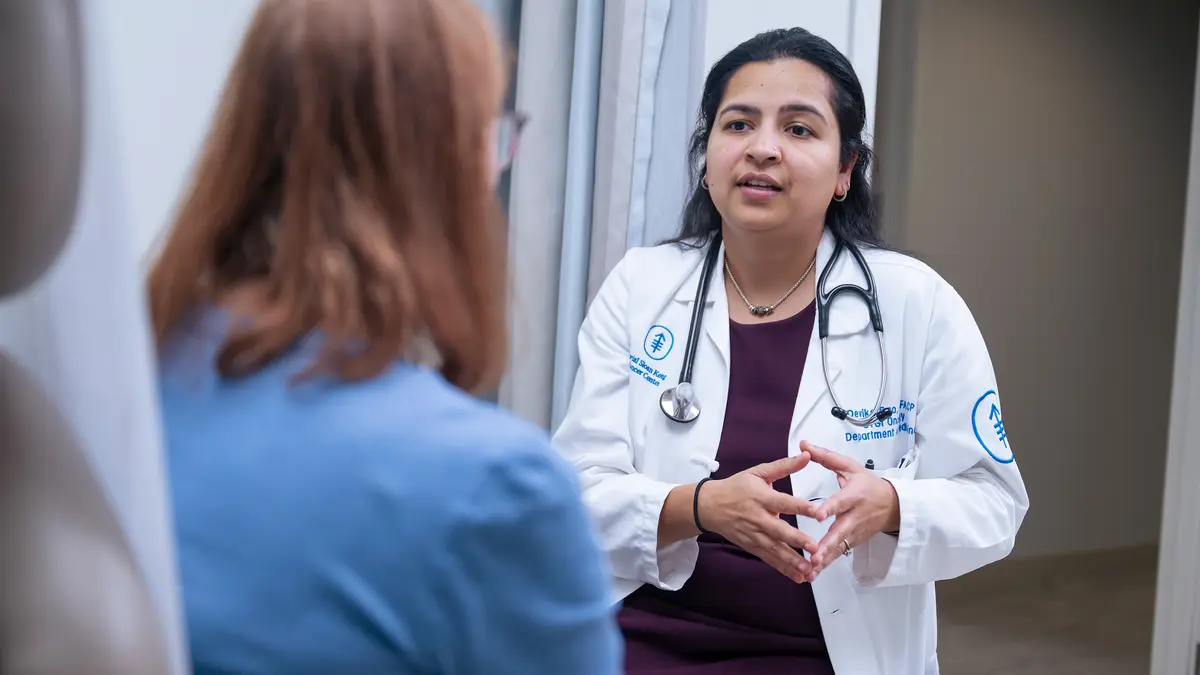 Gastrointestinal medical oncologist Dr. Devika Rao, talking with a patient, treats colon cancer at MSK in New Jersey.