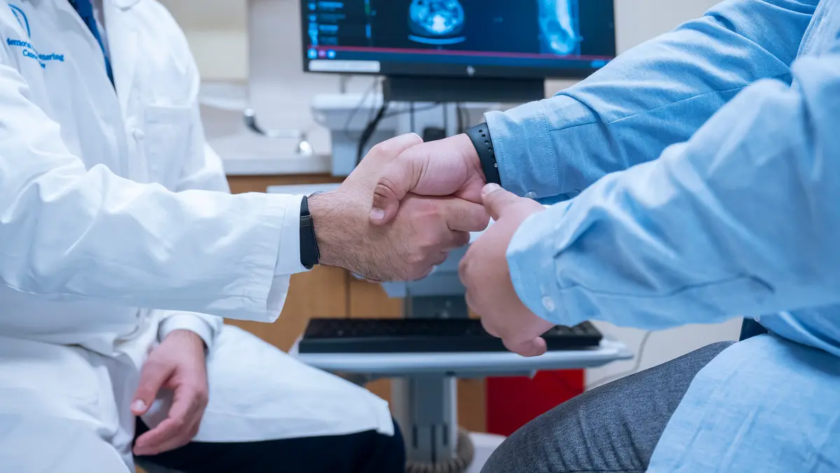 Colorectal surgeon Dr. Mohammad Ali Abbass shakes hands with his MSK patient in an exam room.  