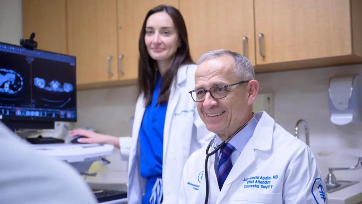 Colorectal cancer surgeon Dr. Julio Garcia-Aguilar talks with a patient, as a nurse shows a scan on a computer monitor. 