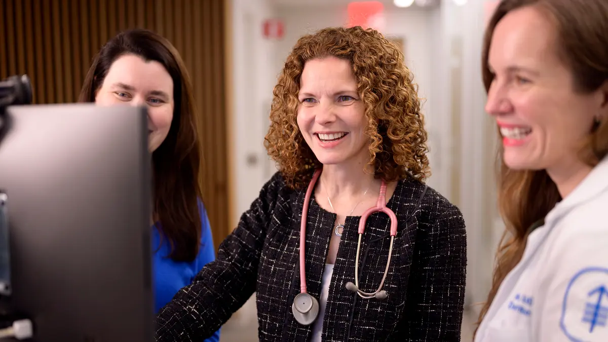 Lead Genetic Counselor Margaret Sheehan; gastrointestinal medical oncologist and clinical geneticist Dr. Zsofia K. Stadler; and family medicine doctor and clinical geneticist Alicia Latham smile as they look at a computer monitor. 