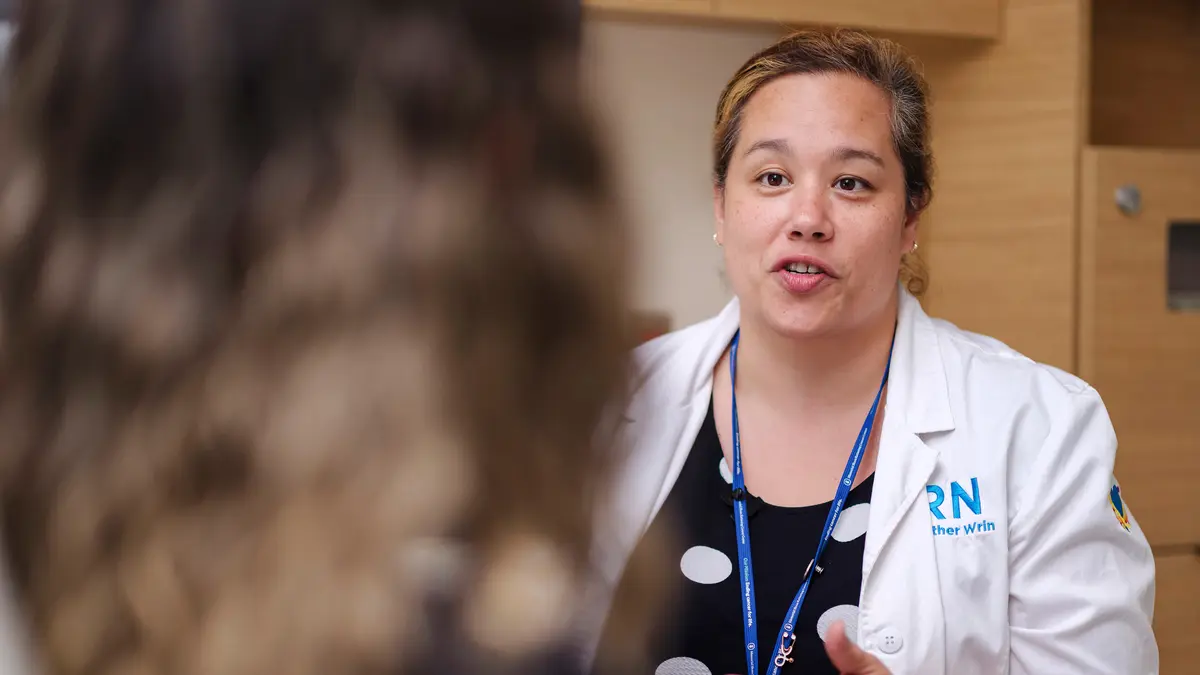 A registered nurse with MSK’s Head and Neck service talks with a patient. 