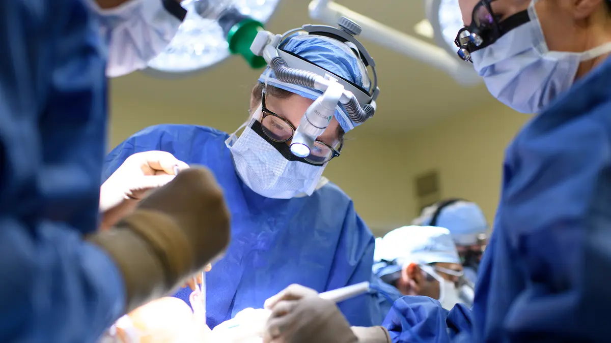 Head and neck surgeon Dr. Jennifer R. Cracchiolo, with 2 other surgeons, during surgery to rebuild a patient’s jaw. 