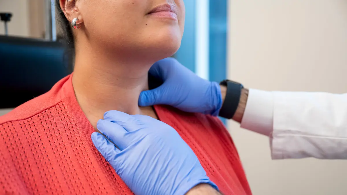 Head and neck surgeon Dr. Babak Givi uses his gloved hands to examine the throat of an MSK patient.  