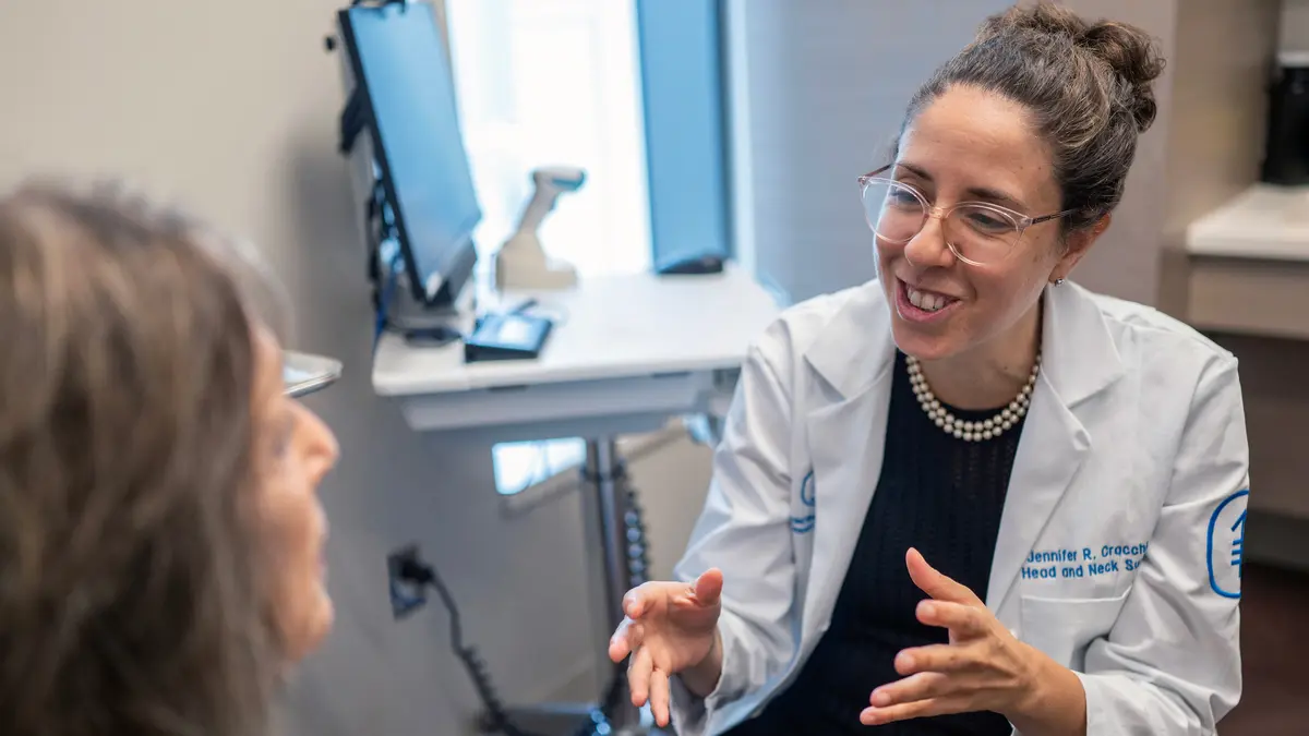 Head and neck surgeon Dr. Jennifer Cracchiolo talks with her patient in an MSK exam room.   