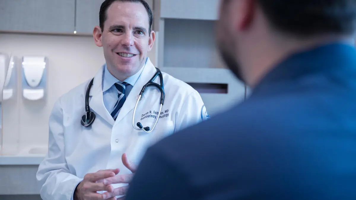 Doctor in white coat talking to a patient.