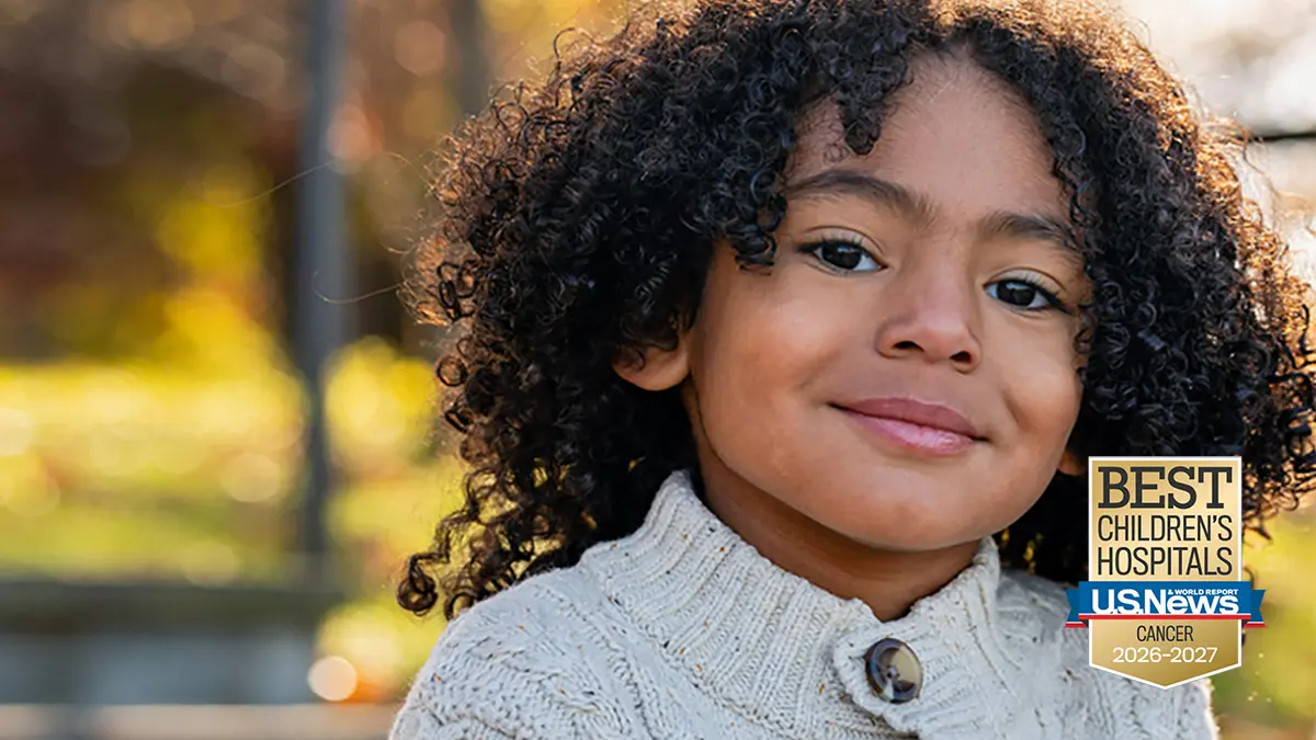 A young child is pictured outside during the daytime.