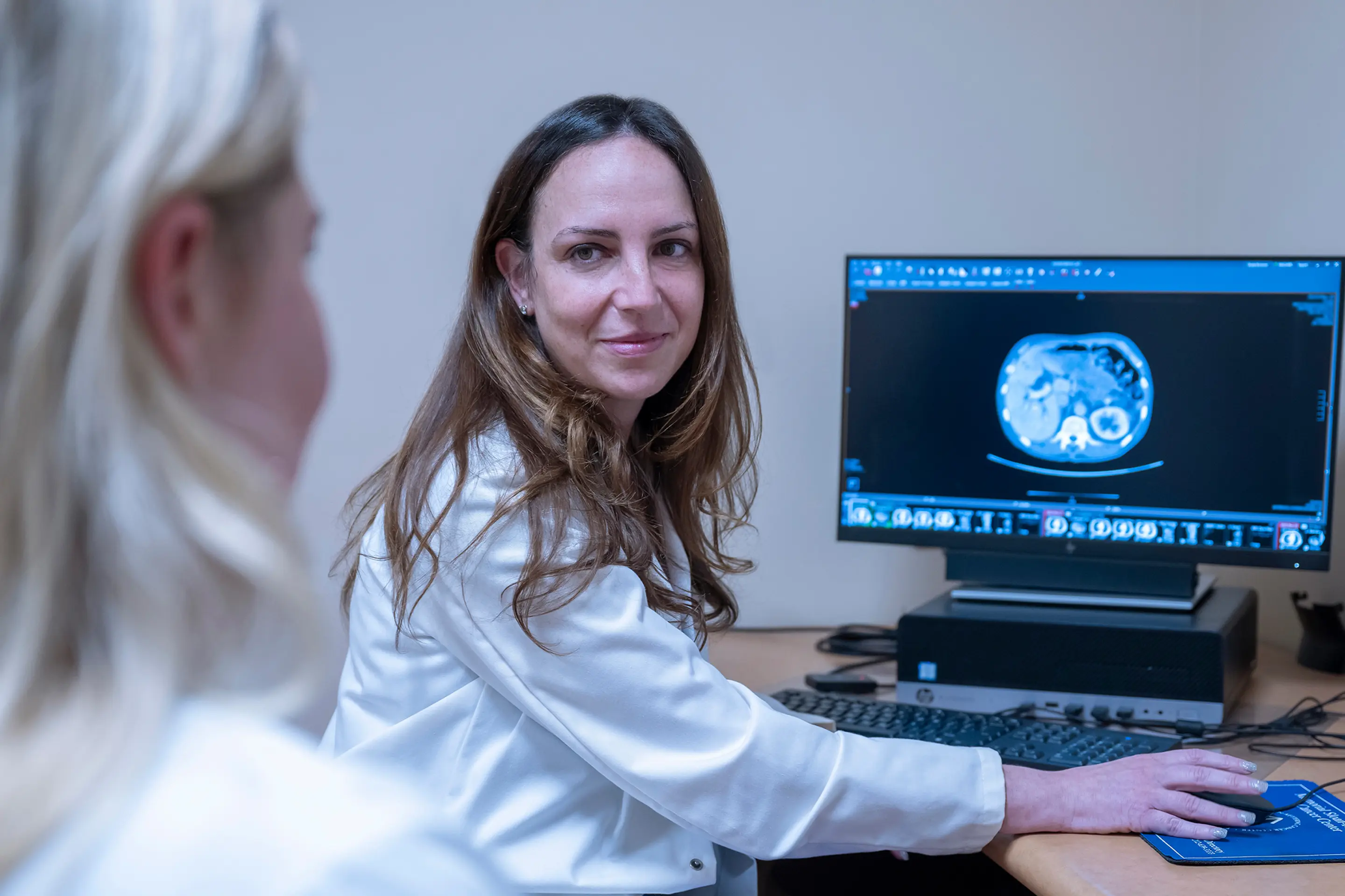 MSK gastroenterologist Dr. Robin Mendelsohn sits at a computer and reviews an imaging scan with an MSK colleague. 